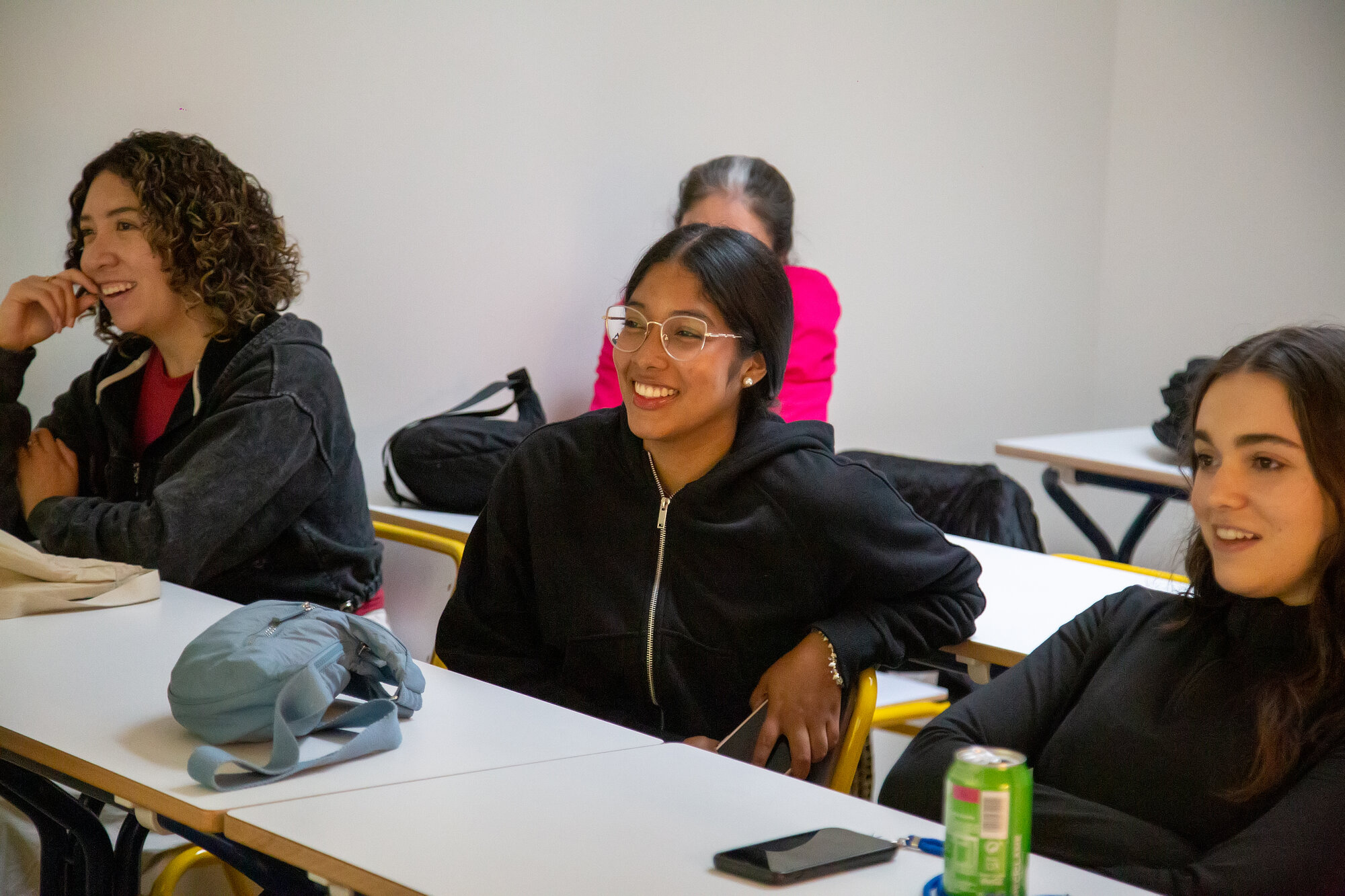 Three students smiling in a Catalan class at BCNLIP